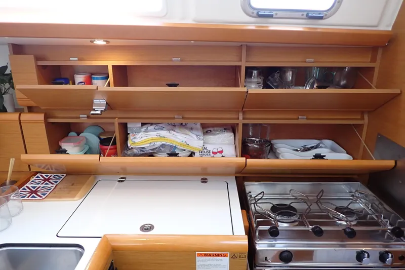 Slide: The Image of 2018 Jeanneau Sun Odyssey 389 yacht kitchen with wooden cabinets and stove. - 104
