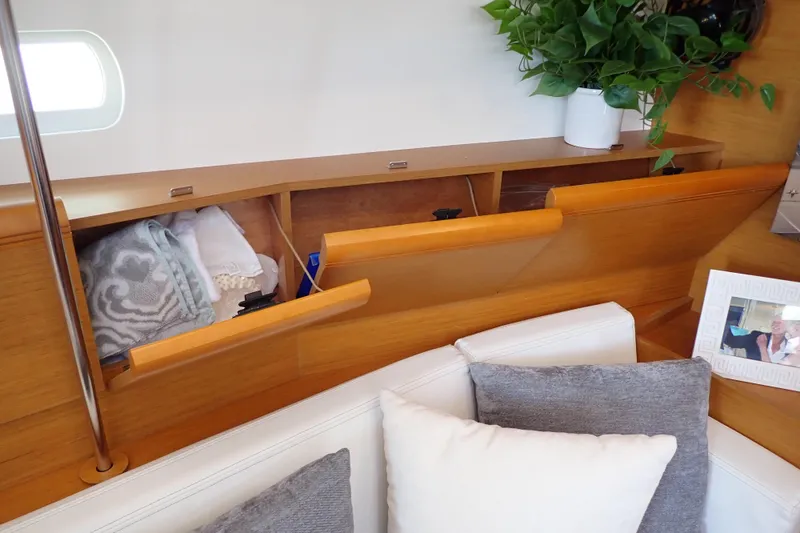 Slide: The Image of Interior of 2018 Jeanneau Sun Odyssey 389 with wooden storage, cushions, and decor. - 119