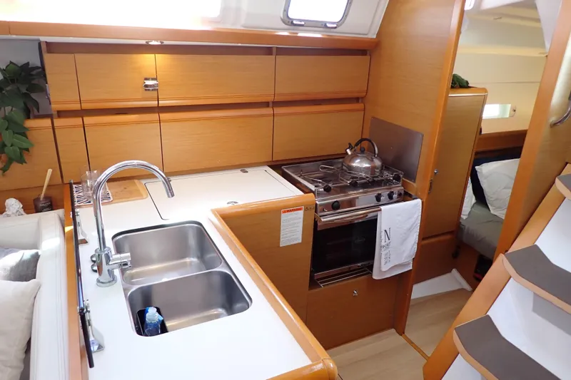 Slide: The Image of 2018 Jeanneau Sun Odyssey 389 yacht kitchen with modern amenities and wooden cabinetry. - 12