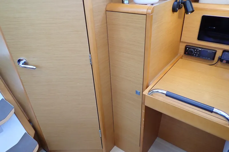 Slide: The Image of 2018 Jeanneau Sun Odyssey 389 interior with wooden cabinetry and navigation equipment. - 122