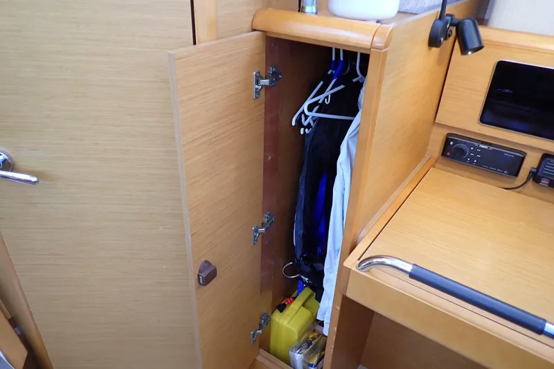 Slide: The Image of Interior of 2018 Jeanneau Sun Odyssey 389 showing a wooden closet with hanging clothes. - 123