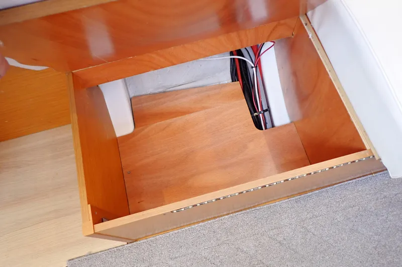 Slide: The Image of Storage compartment in 2018 Jeanneau Sun Odyssey 389 sailboat, featuring wooden interior and wiring. - 127