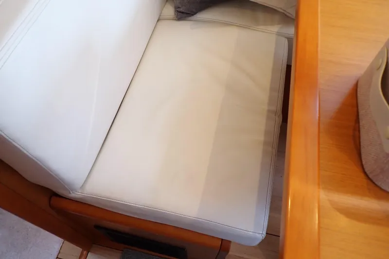 Slide: The Image of Interior seating of 2018 Jeanneau Sun Odyssey 389 yacht, featuring white upholstery and wooden accents. - 131