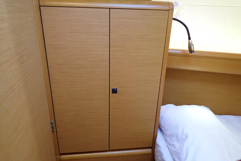 Slide: The Image of Wooden cabin interior of 2018 Jeanneau Sun Odyssey 389 yacht with bed and reading light. - 144