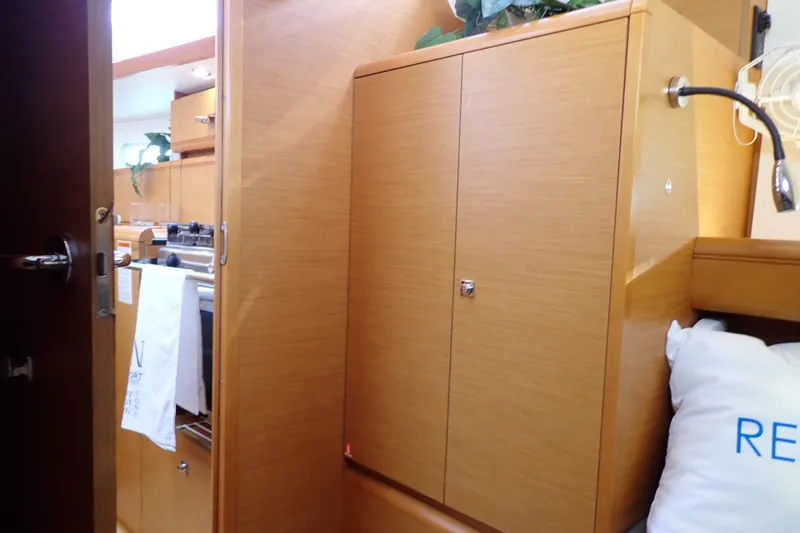 Slide: The Image of Interior of 2018 Jeanneau Sun Odyssey 389 yacht, featuring wooden cabinetry and cozy decor. - 151