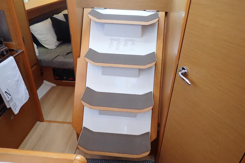 Slide: The Image of Interior of 2018 Jeanneau Sun Odyssey 389 sailboat with wooden steps and cozy cabin. - 157