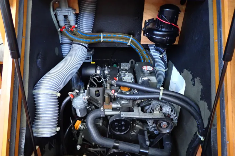 Slide: The Image of Engine compartment of 2018 Jeanneau Sun Odyssey 389 sailboat, showcasing mechanical components and hoses. - 158