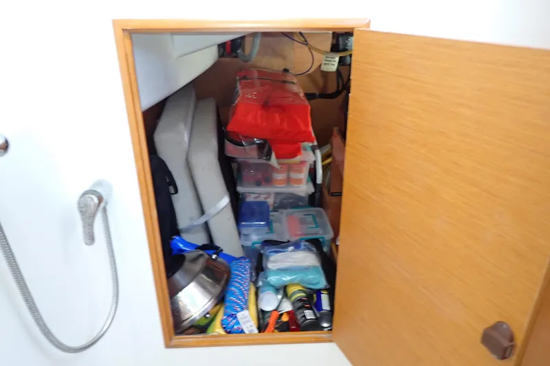 Slide: The Image of Storage compartment on 2018 Jeanneau Sun Odyssey 389 yacht, filled with various supplies and equipment. - 181