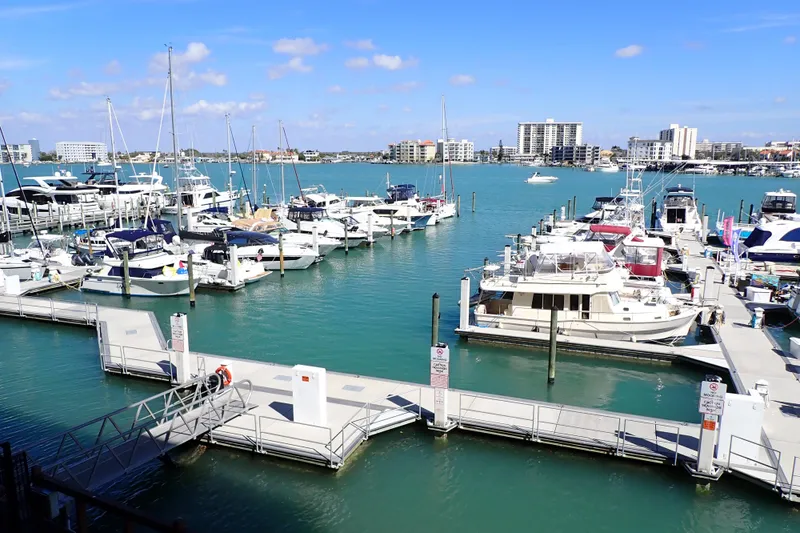 Slide: The Image of Marina with various boats, including a 2018 Jeanneau Sun Odyssey 389, under a clear blue sky. - 196