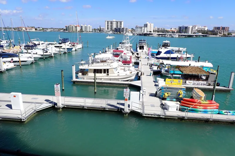 Slide: The Image of Marina with various boats, including a 2018 Jeanneau Sun Odyssey 389, under a clear blue sky. - 197