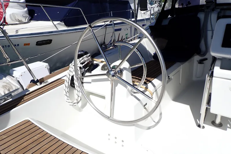 Slide: The Image of Steering wheel of 2018 Jeanneau Sun Odyssey 389 sailboat, featuring sleek design and wooden deck. - 21