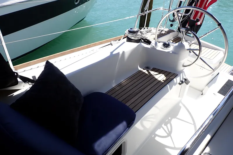 Slide: The Image of Cockpit of 2018 Jeanneau Sun Odyssey 389 sailboat with wooden seating and steering wheel. - 29