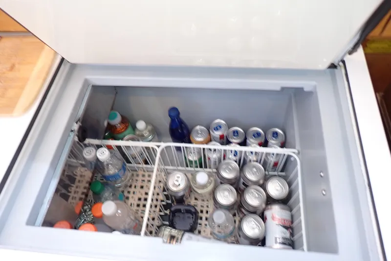 Slide: The Image of Open fridge on Jeanneau Sun Odyssey 389 yacht, stocked with drinks and beverages. - 49