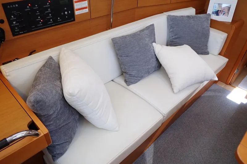 Slide: The Image of White cushioned seating with gray pillows in 2018 Jeanneau Sun Odyssey 389 yacht interior. - 55