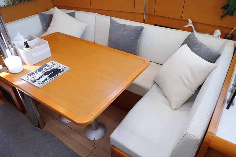 Slide: The Image of Cozy interior of 2018 Jeanneau Sun Odyssey 389 with cushioned seating and wooden table. - 56