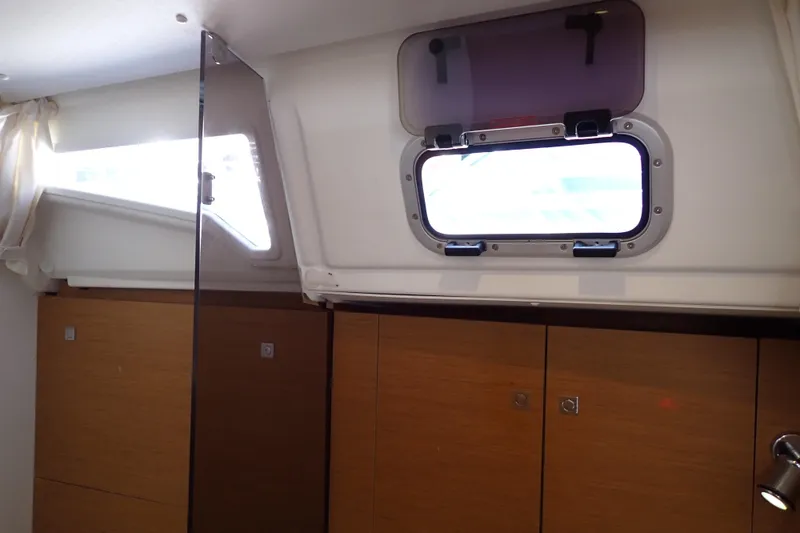 Slide: The Image of Interior cabin of 2018 Jeanneau Sun Odyssey 389 sailboat with wooden cabinets and porthole. - 71
