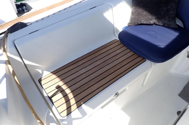 Slide: The Image of Cockpit seating on 2018 Jeanneau Sun Odyssey 389 with wooden flooring and blue cushion. - 89