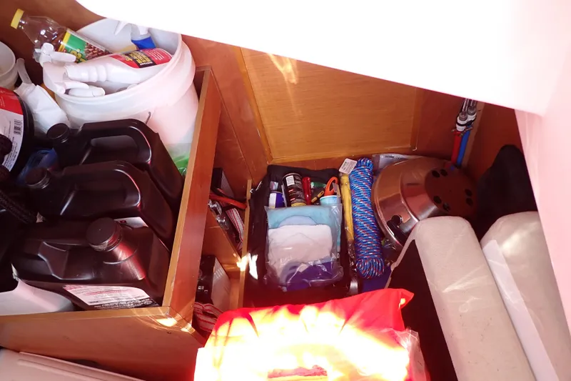 Slide: The Image of Storage compartment in a 2018 Jeanneau Sun Odyssey 389 yacht, filled with supplies and equipment. - 91