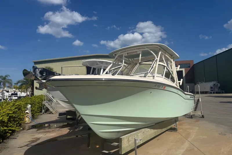 Slide: The Image of 2023 Grady-White Freedom 235 boat on display under a clear blue sky. - 1
