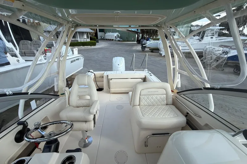 Slide: The Image of 2023 Grady-White Freedom 235 boat interior with luxurious seating and steering wheel. - 6
