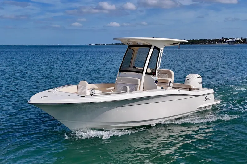 Slide: The Image of 2026 Scout 220 XSF boat cruising on clear blue water under a sunny sky. - 22