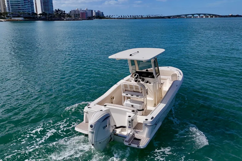 Slide: The Image of 2026 Scout 220 XSF boat cruising on clear blue water near city skyline. - 27