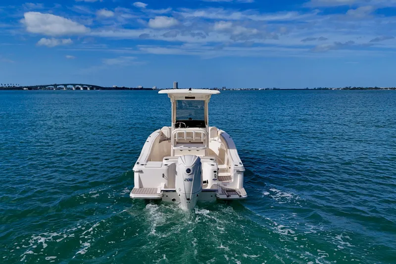 Slide: The Image of 2026 Scout 220 XSF boat cruising on open water under a clear blue sky. - 28