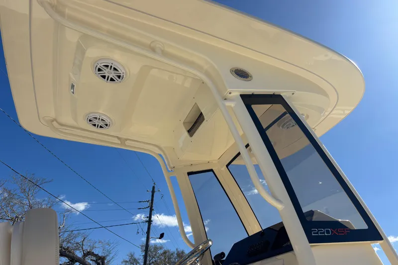 Slide: The Image of 2026 Scout 220 XSF boat canopy and console under clear blue sky. - 7