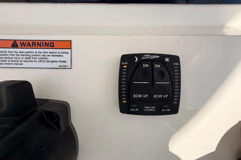 Slide: The Image of 2024 Cobia 262 Center Console trim tab control panel with warning label. - 21