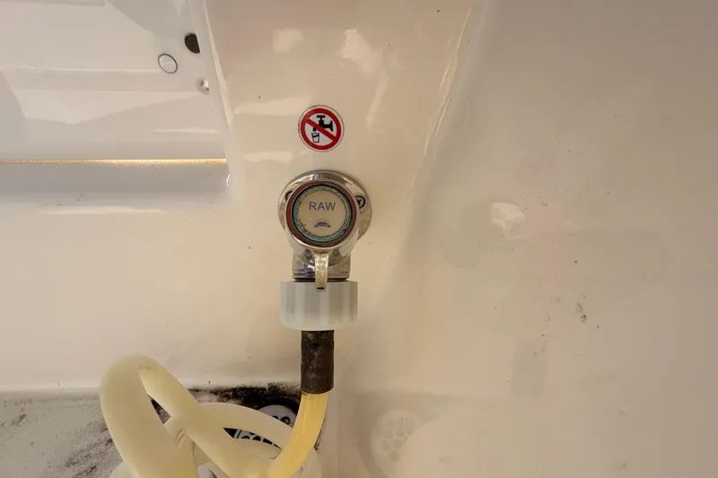 Slide: The Image of 2024 Cobia 262 Center Console raw water washdown outlet with hose attachment. - 29