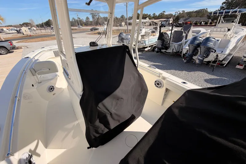 Slide: The Image of 2024 Cobia 262 Center Console boat interior with covered console, parked in a marina. - 34