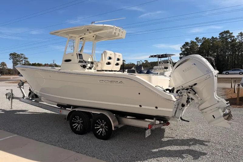Slide: The Image of 2024 Cobia 262 Center Console boat on trailer, featuring dual outboard engines. - 4