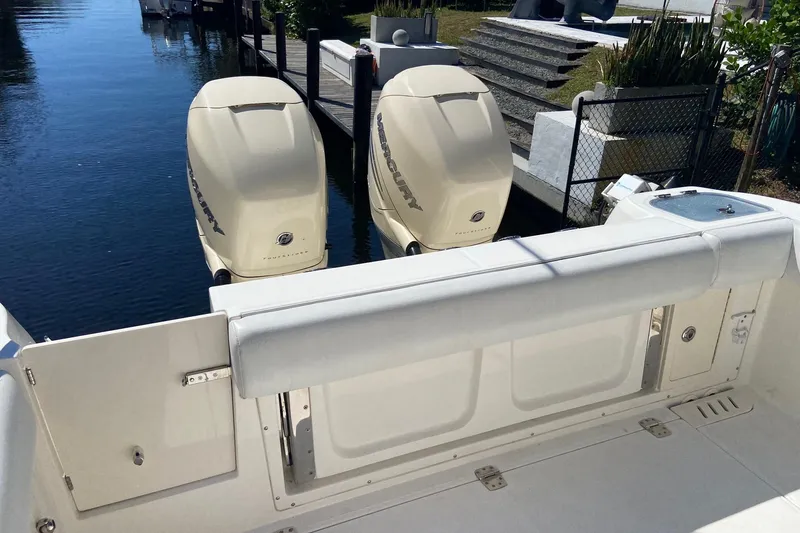 Slide: The Image of 2011 Boston Whaler 320 Outrage with twin Mercury outboard engines docked by the water. - 12