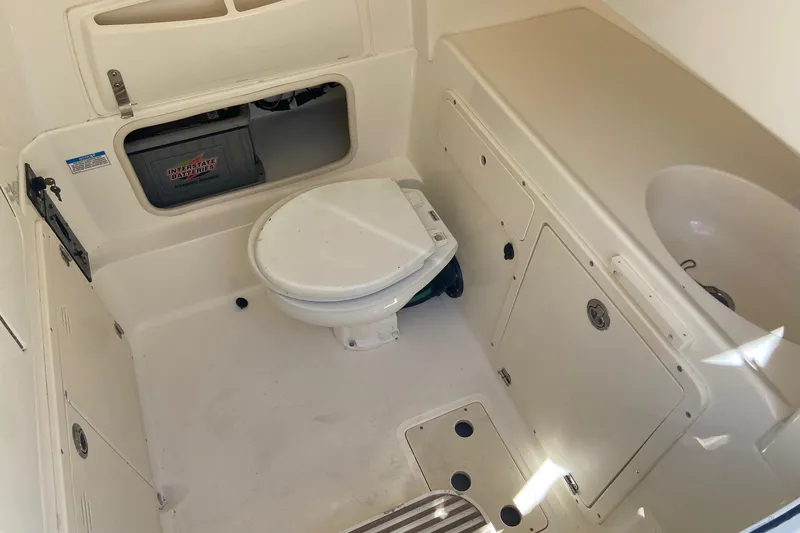 Slide: The Image of 2011 Boston Whaler 320 Outrage boat interior with toilet and storage compartments. - 17
