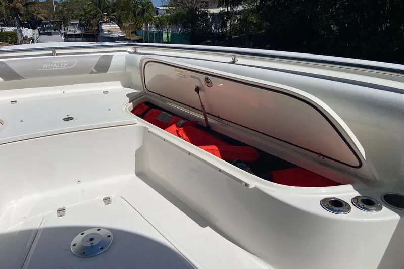 Slide: The Image of 2011 Boston Whaler 320 Outrage boat with open storage compartment and life jackets. - 25