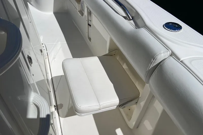 Slide: The Image of 2011 Boston Whaler 320 Outrage interior with white cushioned seat and stainless steel handle. - 29