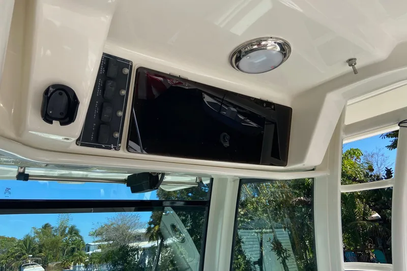Slide: The Image of 2011 Boston Whaler 320 Outrage interior with control panel and overhead light. - 31