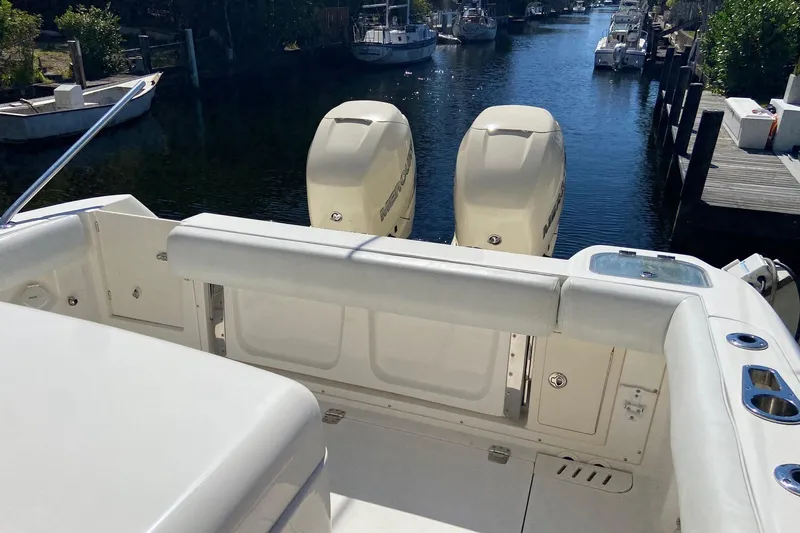Slide: The Image of 2011 Boston Whaler 320 Outrage boat with twin outboard engines docked in a canal. - 32
