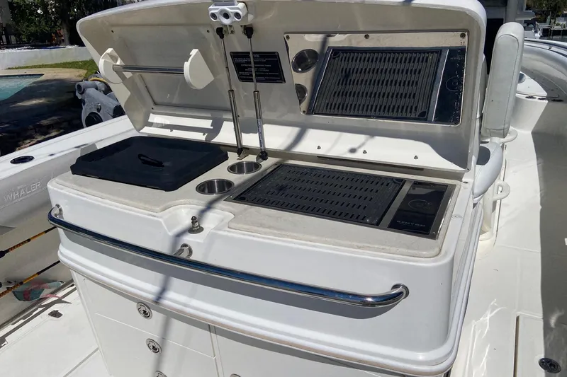 Slide: The Image of 2011 Boston Whaler 320 Outrage boat grill station with storage and cup holders. - 9