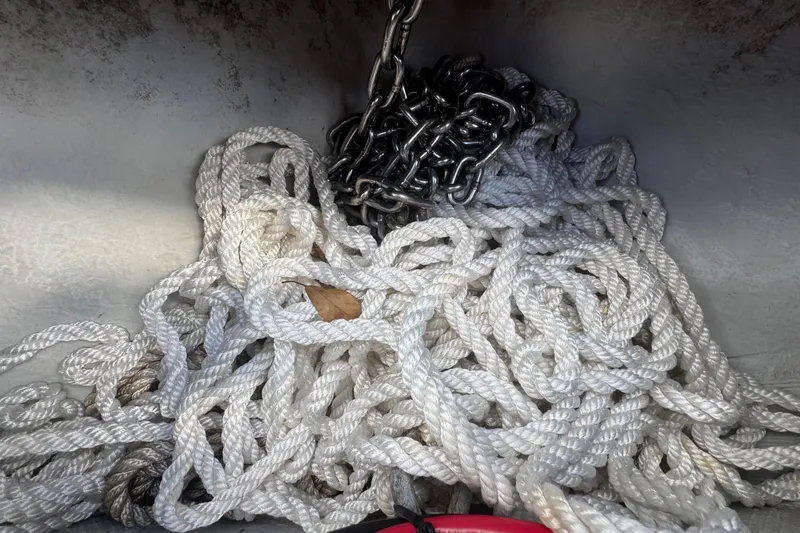 Slide: The Image of Tangled white rope and chain in a 2001 Cobia 254 Center Console boat. - 11