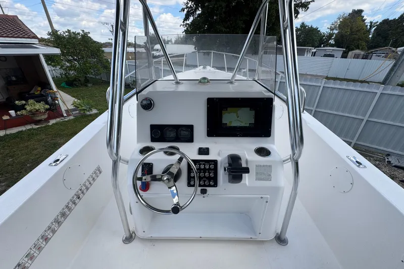 Slide: The Image of 2001 Cobia 254 Center Console boat dashboard with steering wheel and navigation display. - 20