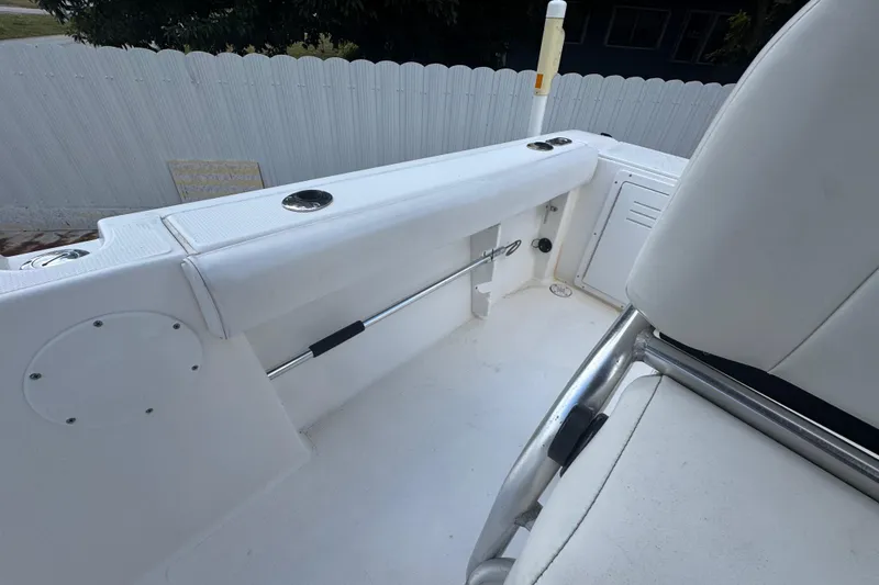 Slide: The Image of 2001 Cobia 254 Center Console boat interior with white seating and rod holders. - 29