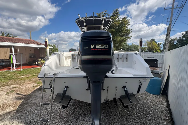 Slide: The Image of 2001 Cobia 254 Center Console boat with Yamaha V250 outboard motor in a backyard setting. - 3