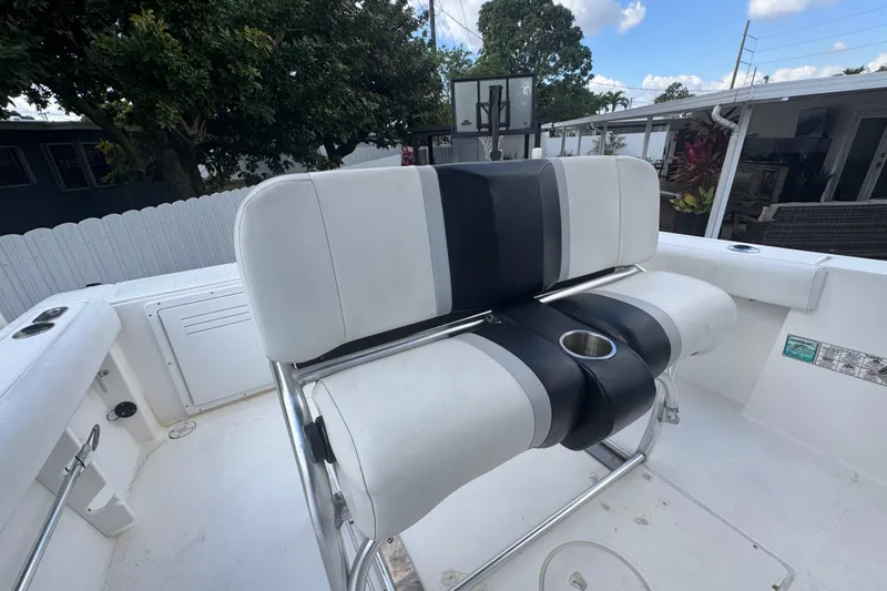 Slide: The Image of 2001 Cobia 254 Center Console boat with white and black seating, outdoor setting. - 31