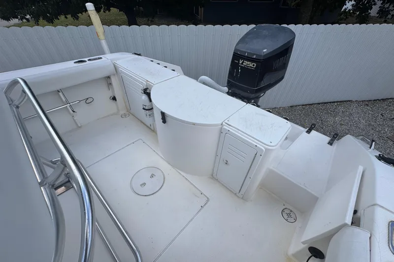 Slide: The Image of 2001 Cobia 254 Center Console boat with Yamaha V250 outboard motor, white deck, and storage compartments. - 33