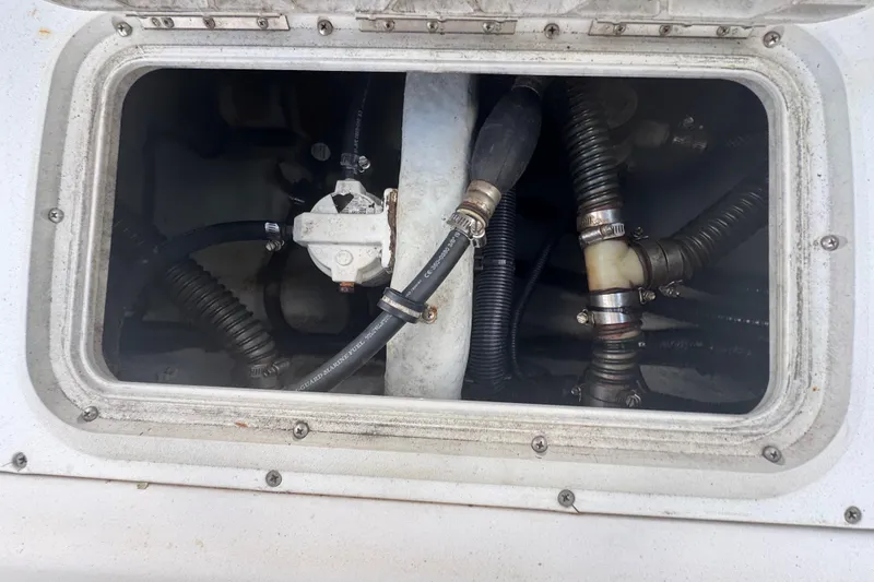 Slide: The Image of 2001 Cobia 254 Center Console boat compartment with hoses and fittings. - 38