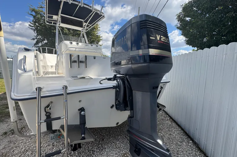 Slide: The Image of 2001 Cobia 254 Center Console boat with Yamaha V250 outboard motor, parked on gravel. - 42