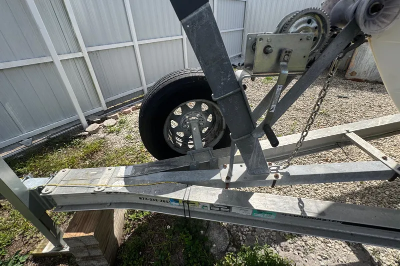 Slide: The Image of Trailer for 2001 Cobia 254 Center Console boat, parked on gravel. - 7