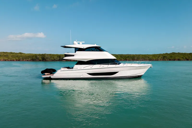 Slide: The Image of 2024 Maritimo M55 yacht cruising on serene blue waters under clear skies. - 11