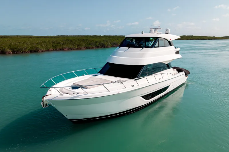 Slide: The Image of 2024 Maritimo M55 yacht cruising on turquoise waters under a clear sky. - 2